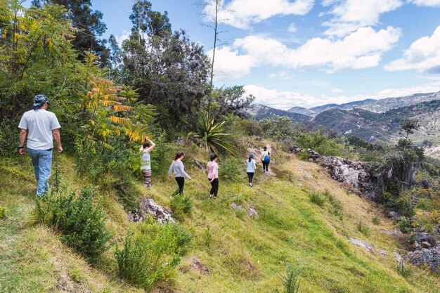 Grupa turystów spacerujących wąską ścieżką na górze