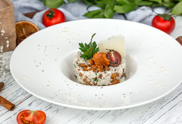 Grzybowe risotto z grzybami przyozdobione parmezanem i natką pietruszki