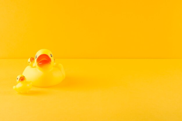 Gumowa kaczka i kaczątka na żółtym tle