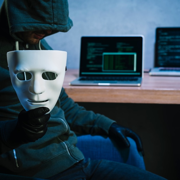 Bezpłatne zdjęcie hacker trzyma maskę