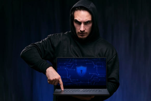 Haker ze średnim strzałem trzymający laptopa