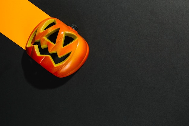 Bezpłatne zdjęcie halloweenowa bania kłaść na pomarańczowym prześcieradle papier