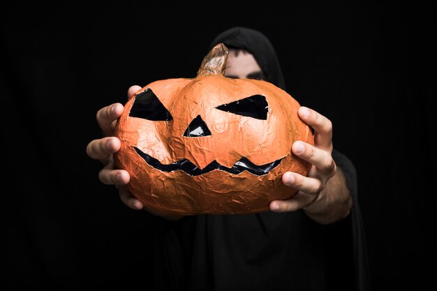 Halloweenowa bania w rękach młody człowiek