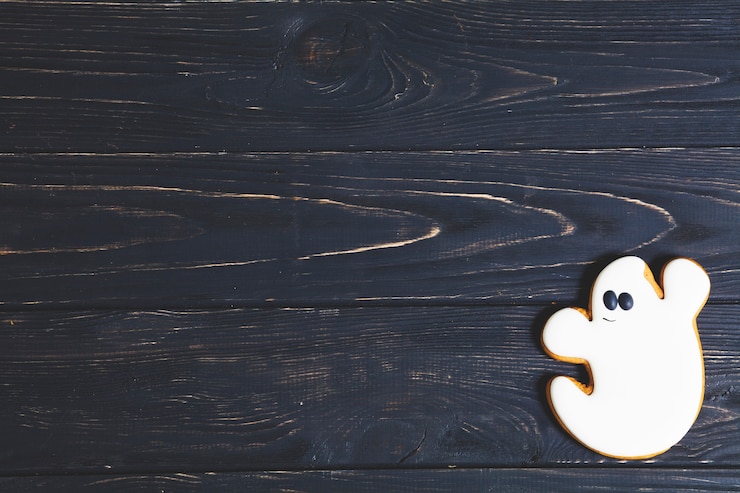 Bezpłatny plik Zdjęcie halloweenowy ducha ciastko na czarnym drewnianym stole