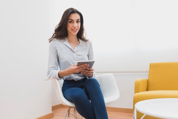 Happy businesswoman siedzi i trzyma tablet