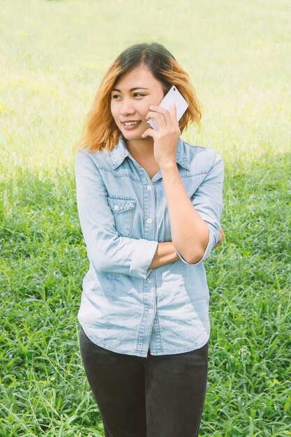 Happy nastolatka z jej telefonu komórkowego na łące