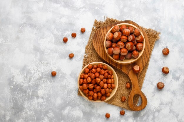 Hazelnut z obranymi hazelnuts w małym talerzu na betonie, odgórny widok.