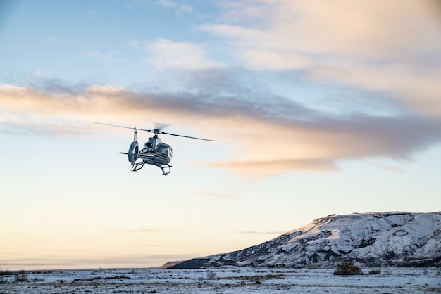 Helikopter leci nad pokrytą śniegiem tundrą