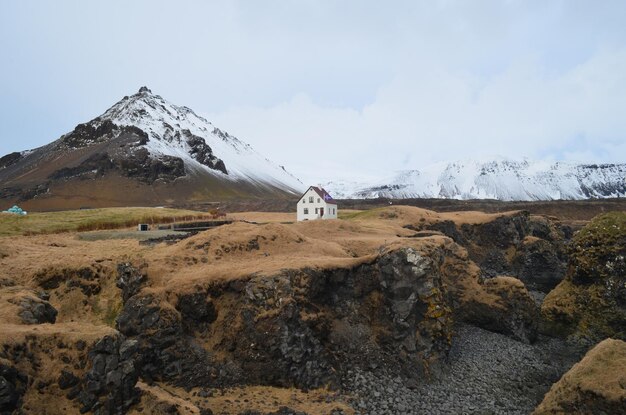 Hellnar Islandię otaczają surowy krajobraz i pokryte śniegiem góry.