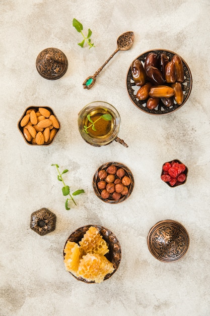 Herbaciany szkło z datami owoc i dokrętki na stole