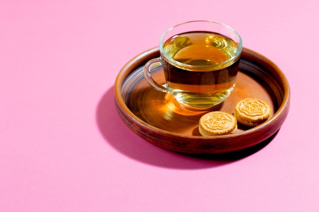 Herbata w filiżance z deserem na jasnym kolorowym tle
