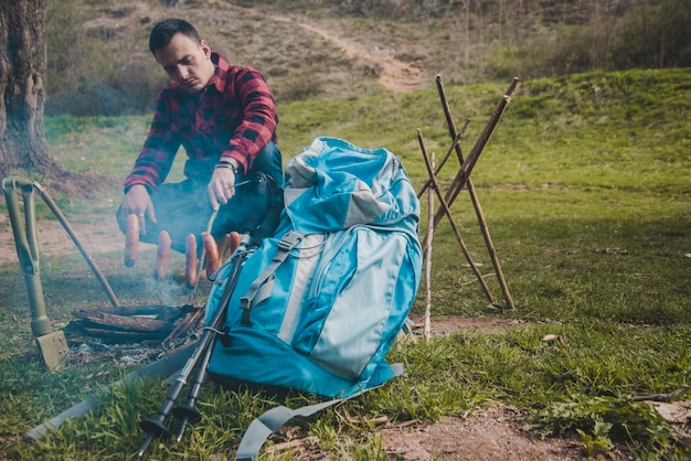 Hiker przygotowuje kiełbasy na ognisku