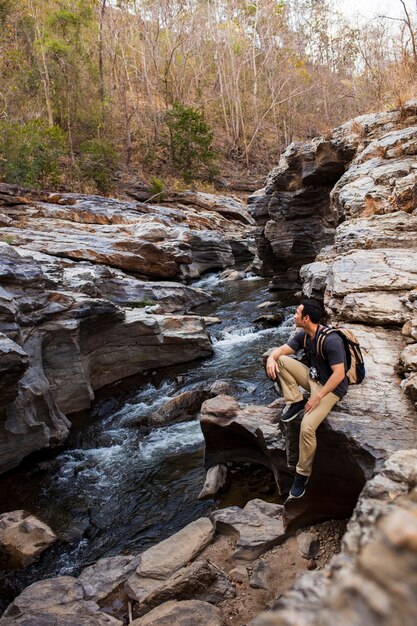 Hiker siedzący obok dzikiej rzeki