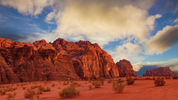 Hipnotyzujący widok na piaszczyste skaliste klify pod zachmurzonym błękitnym niebem na pustyni