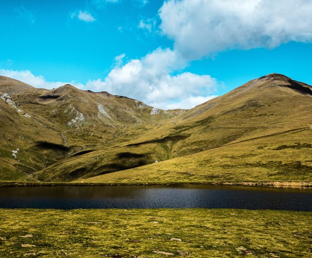 Hipnotyzujący widok na Three Peaks Hill i jezioro pod zachmurzonym niebem w Argentynie
