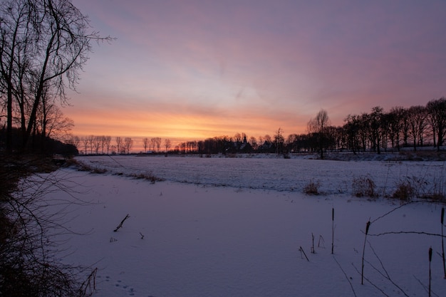 Hipnotyzujący zachód słońca w pobliżu historycznego zamku Doorwerth zimą w Holandii