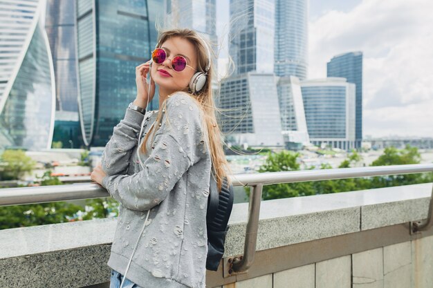 Hipster młoda kobieta, zabawy na ulicy, słuchanie muzyki na słuchawkach