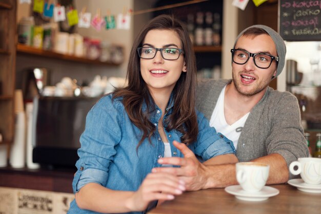 Hipster para rozmawia z przyjaciółmi w kawiarni