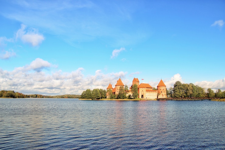 Bezpłatny plik Zdjęcie historyczny trakai kasztel w lithuania blisko jeziora pod pięknym chmurnym niebem