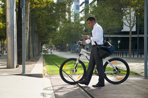 Hiszpanie pracownik biurowy z rowerem i telefonem w ulicy