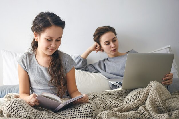 Idealny przytulny obrazek przedstawiający uroczą 10-letnią dziewczynkę cieszącą się ulubioną bajką