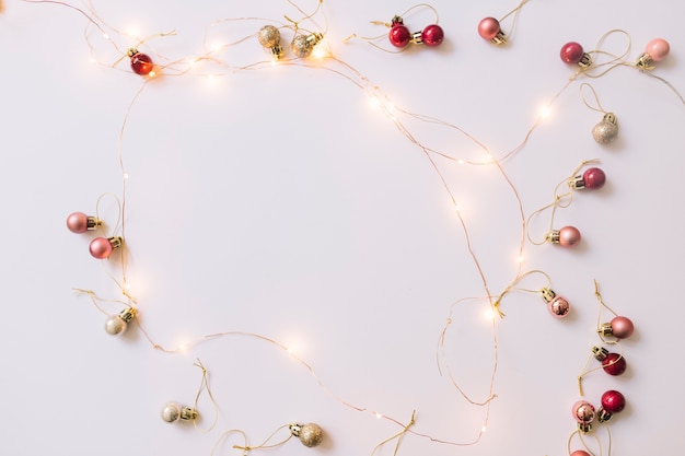 Bezpłatne zdjęcie illuminating fairy lights w pobliżu christmas baubles