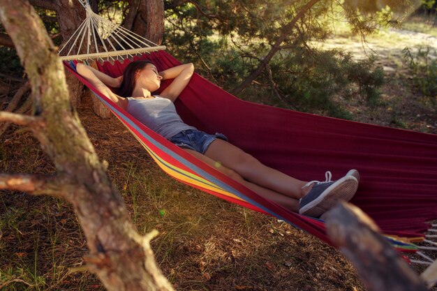 Impreza, camping. Kobieta śpi w lesie. Ona się odpręża