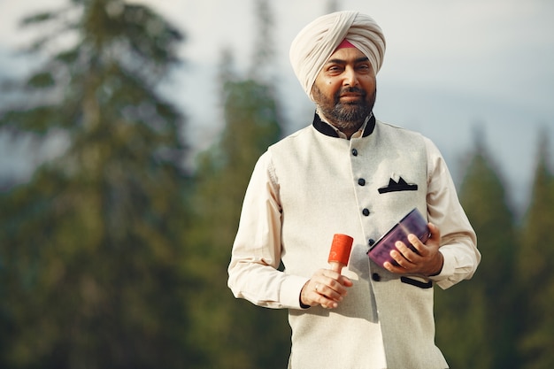 Indianin w górach. Mężczyzna w tradycyjnym turbanie. Hinduista ze specjalnymi rzeczami do rytuałów.