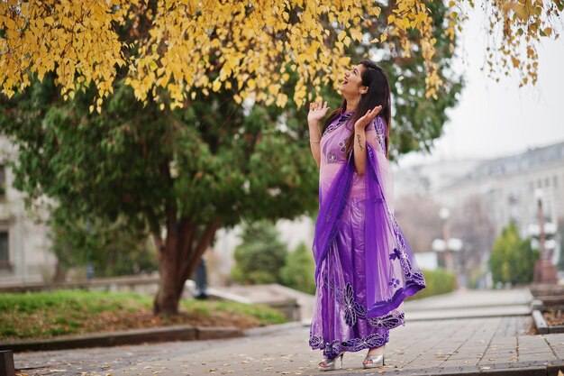 Indyjska hinduska dziewczyna w tradycyjnej fioletowej sari pozowała na jesiennej ulicy