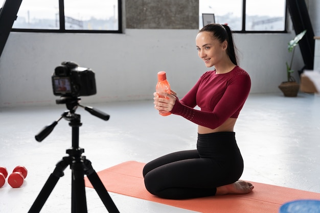 Bezpłatne zdjęcie instruktor fitnessu sportowego online nagrywa swoją sesję