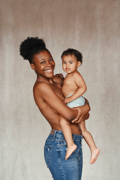 Bezpłatne zdjęcie intymny portret pięknej matki trzymającej swoje dziecko