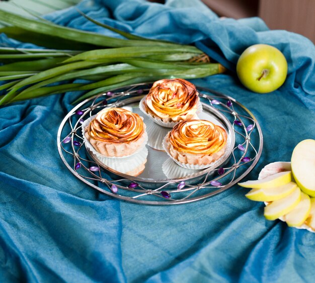 Jabłczane słodkie placki w kształcie kwiatu w talerzu.