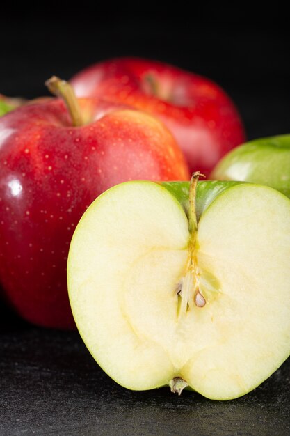 Jabłka czerwone i zielone łagodne dojrzałe soczyste owoce na szarym tle