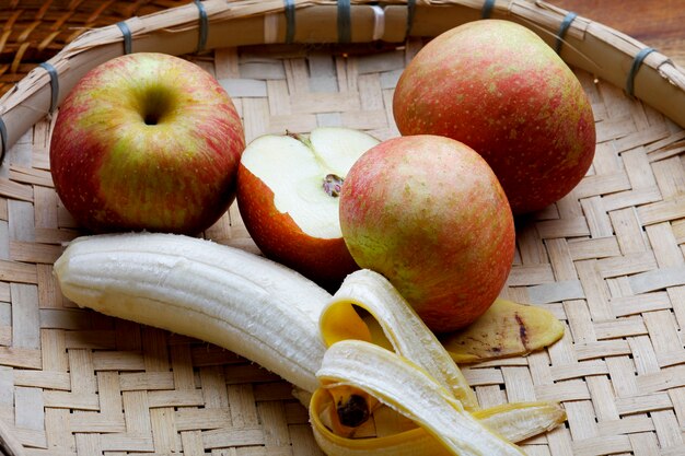 Jabłka i banany w koszu.