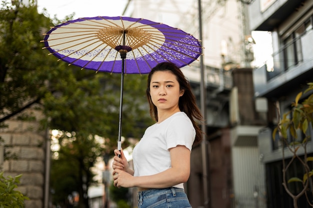 Bezpłatne zdjęcie japońska pomoc parasola wagasa przez młodą kobietę