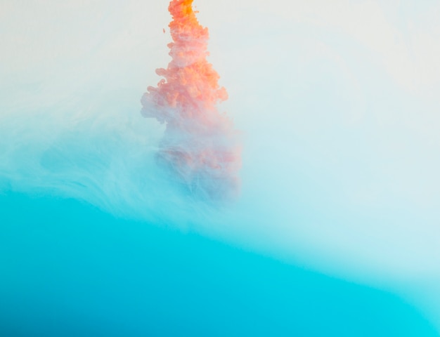 Bezpłatne zdjęcie jasna pomarańczowa kropla w niebieskiej mgle