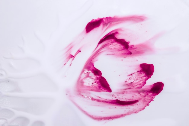 Jasny różowy ręcznie rysowane uderzenia koloru wody nad gładką białą tapetą