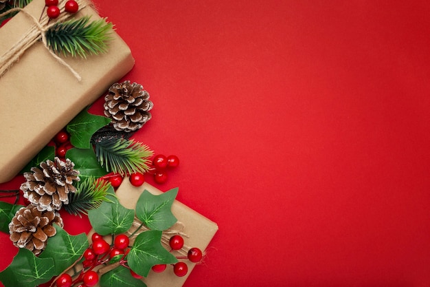 Jemioła, szyszki i prezenty świąteczne na czerwonym stole