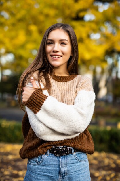 Jesieni kobieta w pulowerze w jesień parku. Ciepła, słoneczna pogoda. Koncepcja upadku
