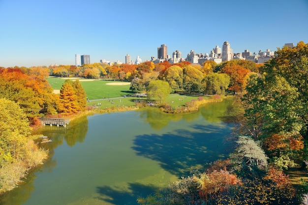 Jezioro i jesienne liście z apartamentowcami w Central Parku na Manhattanie w Nowym Jorku