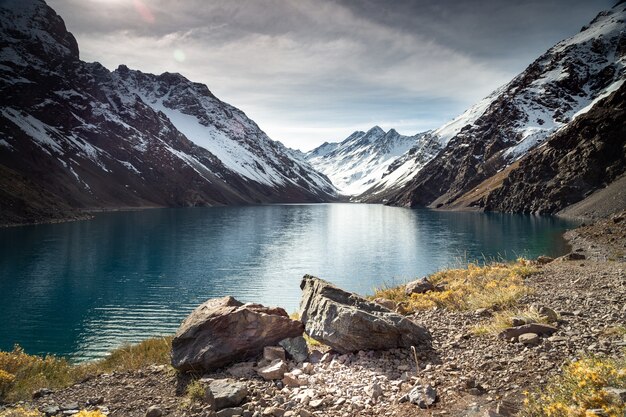 Jezioro Laguna del Inca otoczone wysokimi górami pokrytymi śniegiem w Chile