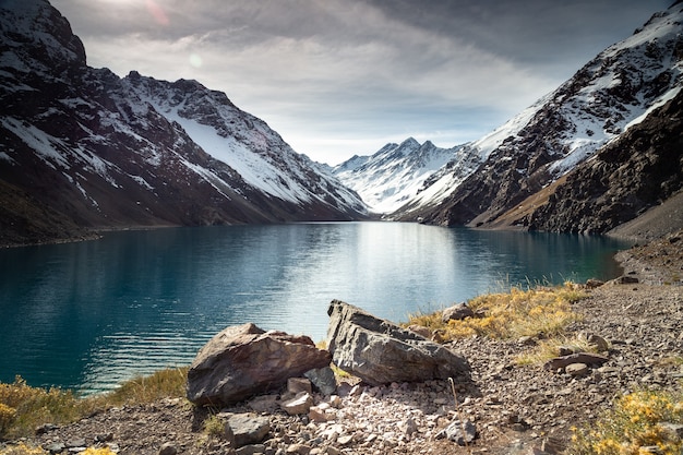 Jezioro Laguna del Inca otoczone wysokimi górami pokrytymi śniegiem w Chile