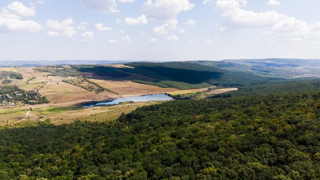 Jezioro położone na nizinie, na pierwszym planie las i wzgórza