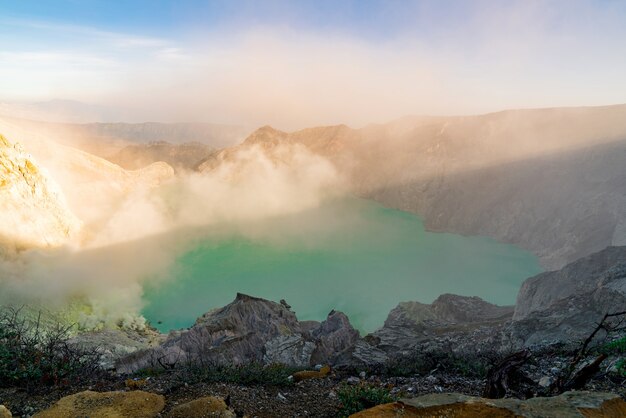Jezioro pośrodku skalistego krajobrazu wyrzucającego dym