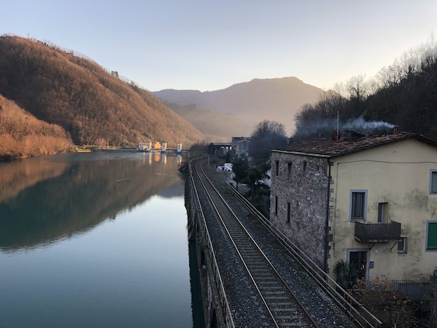 Jezioro Serchio otoczone koleją, budynkami i wzgórzami porośniętymi lasami we Włoszech