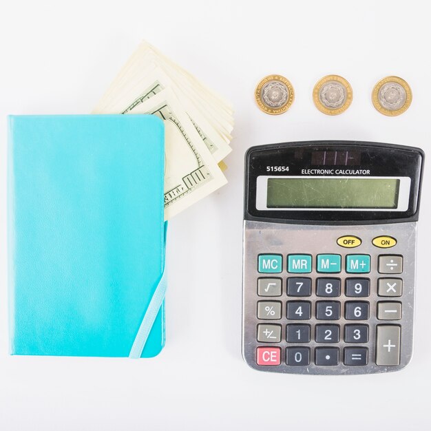 Kalkulator z pieniądze i notatnikiem na stole
