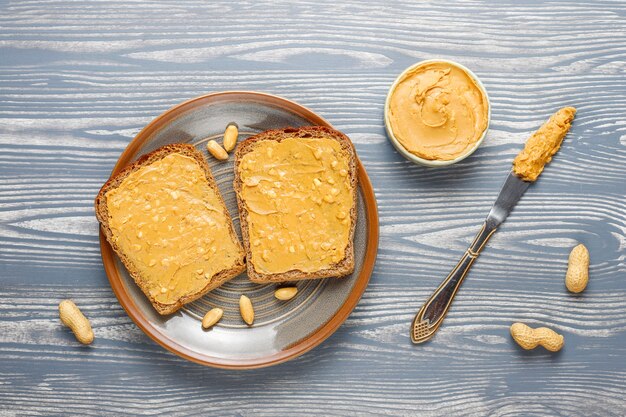 Kanapki lub tosty z masłem orzechowym z konfiturą malinową.
