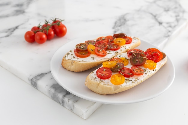 Bezpłatne zdjęcie kanapki z twarogiem i pomidorami na talerzu