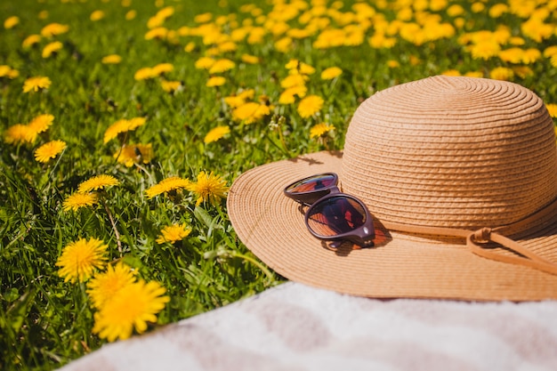 Bezpłatne zdjęcie kapelusz i okulary przeciwsłoneczne z żółtych kwiatów