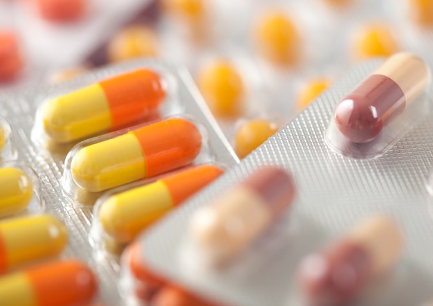 Kapsułka tabletki w plastikowym pasku na białym tle. antybiotyki, witaminy, środek przeciwbólowy.